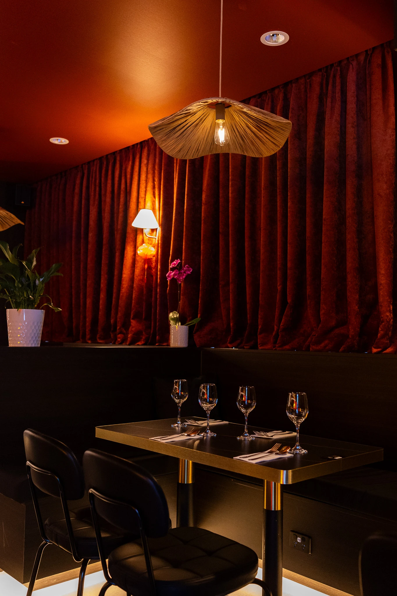 Jaya’s red velvet curtains and warm table lighting