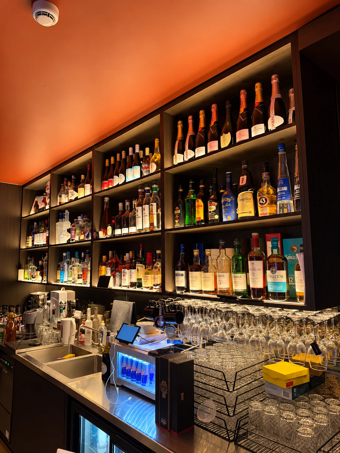 Jaya’s bottle-lined bar and glassware viewed from the side